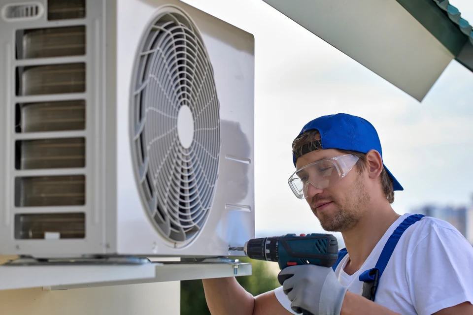 Master installe le boîtier métallique du climatiseur à distance à l'aide d'un tournevis automatique
