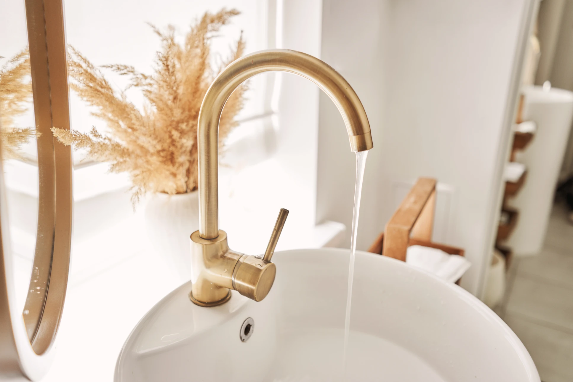 Plombier qualifié au travail effectuant l'installation d'une tuyauterie sanitaire ou d'un équipement de plomberie dans une salle de bain en rénovation. Le professionnel porte tenue de travail appropriée et utilise des outils professionnels. La scène montre clairement l'expertise métier et la qualité du travail, dans une ambiance de chantier professionnel et maîtrisé.